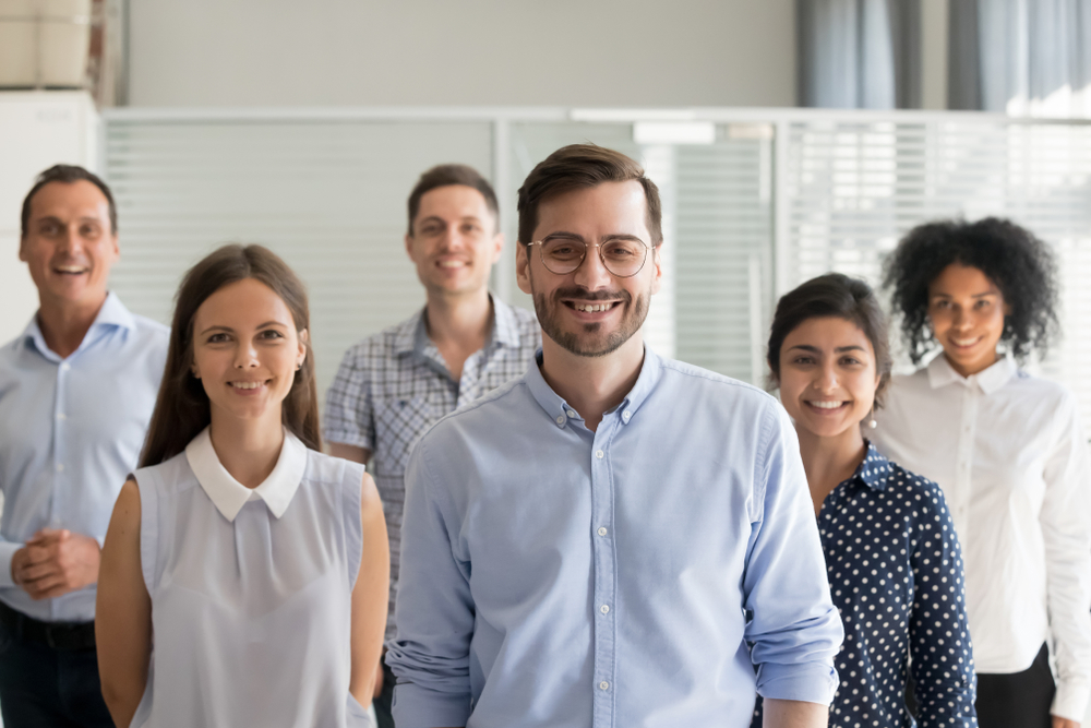 Diverse group of professionals standing in a group and smiling